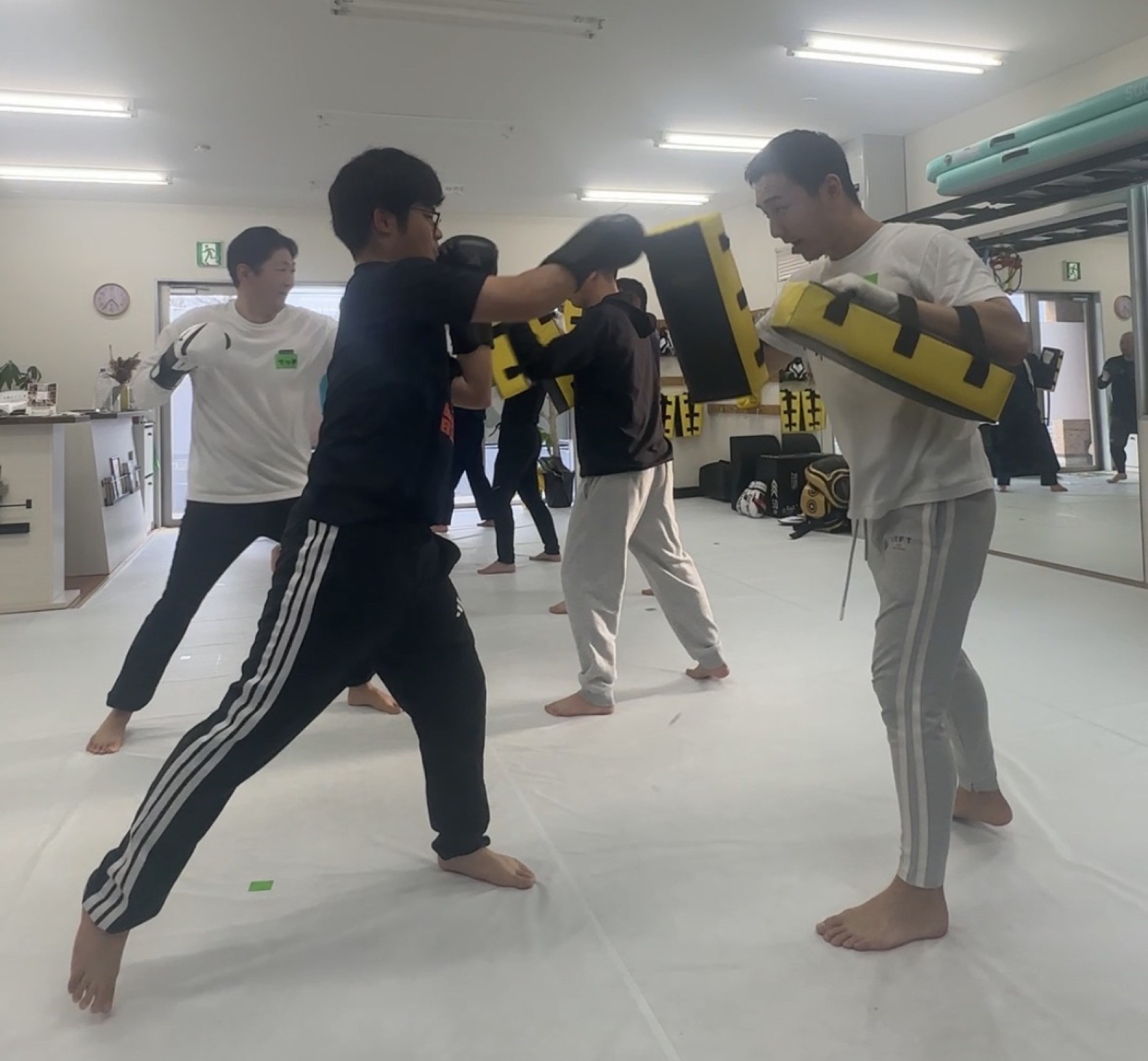 トレーナーがミットを持ち参加者をサポートする様子