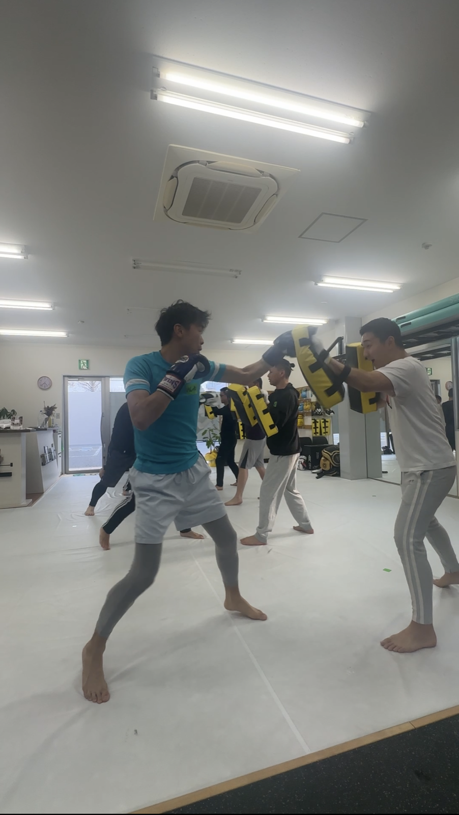 ミットを使って参加者をサポートするトレーナー